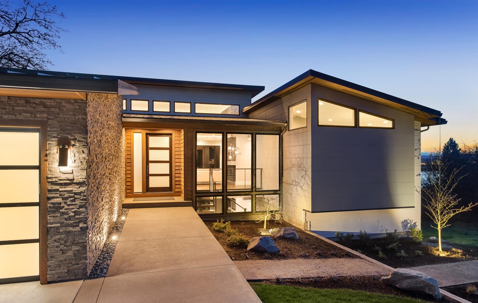 Beautiful modern style luxury home exterior at sunset with glowi