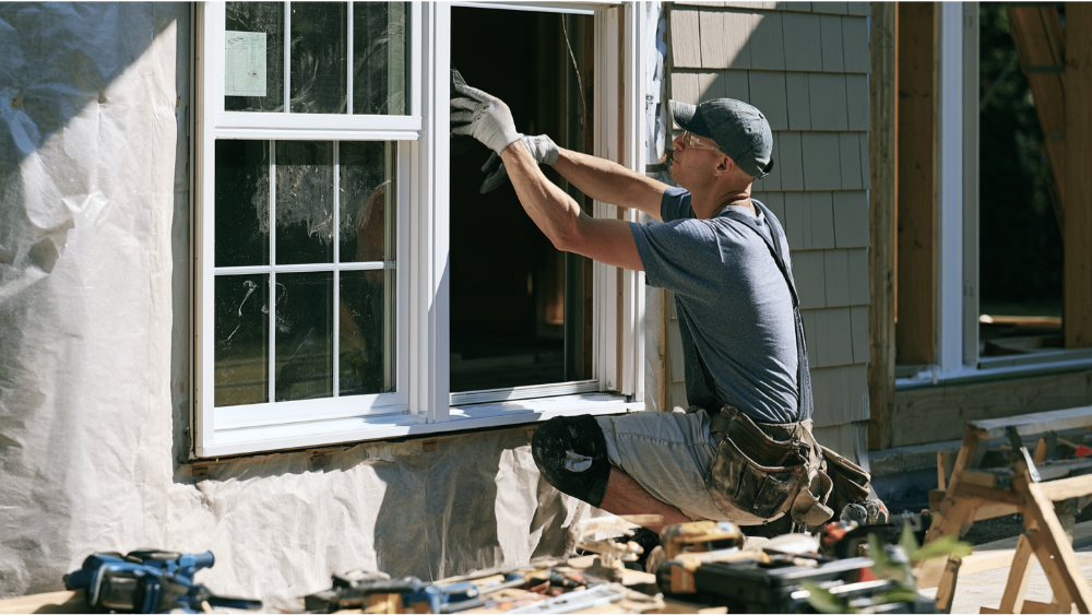 Professional installer carefully fitting a premium casement window into a residential home